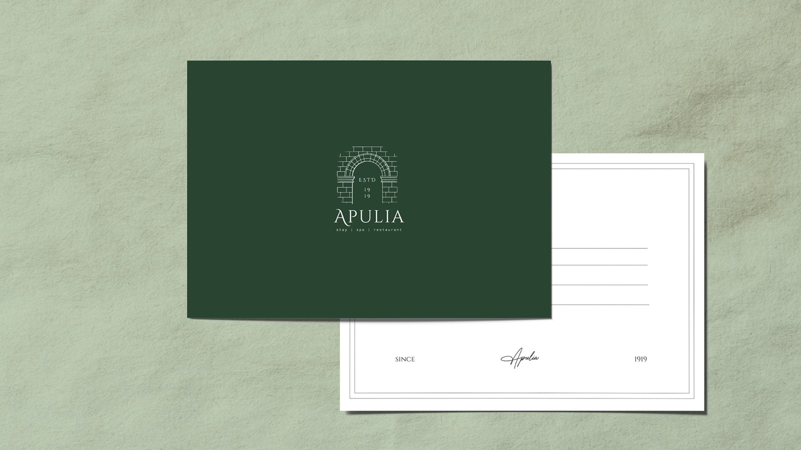 Cartolina verde scuro con l'illustrazione a tratto di un arco in pietra e il logotype Apulia, stay | spa | restaurant, accanto al retro bianco con il corsivo Apulia